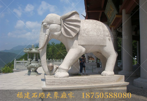 一对石雕大象勾着元宝，伫立在象山宝塔前！