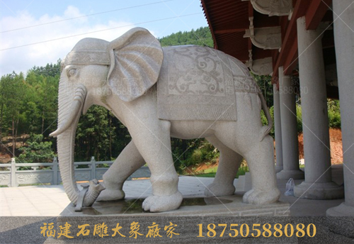 一对石雕大象勾着元宝，伫立在象山宝塔前！